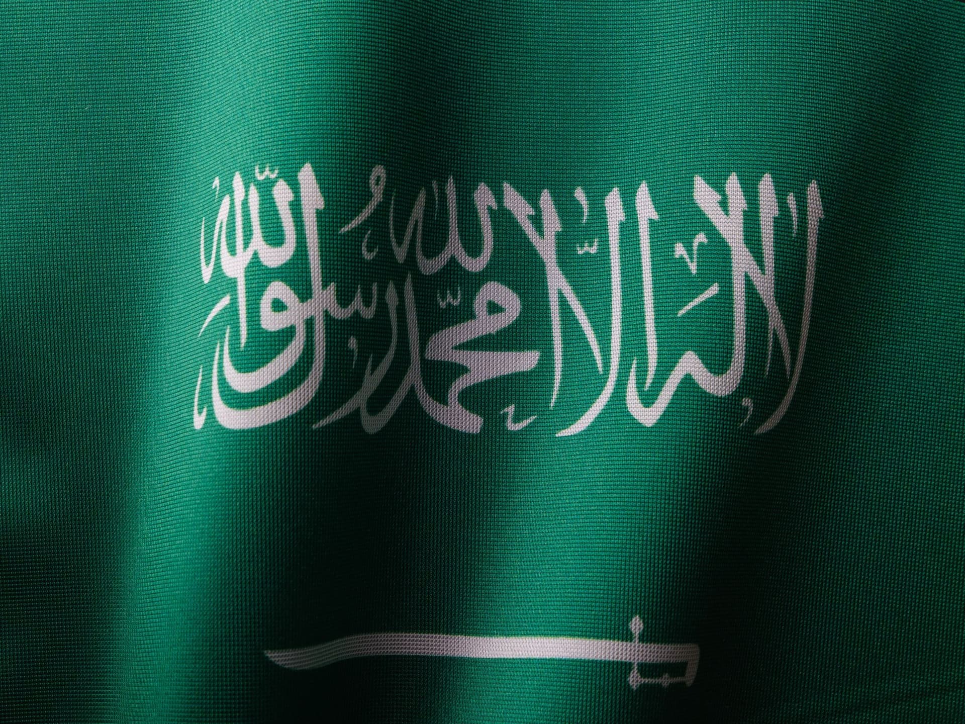 サウジアラビア国旗の接写。緑地に白のシャハーダと剣。