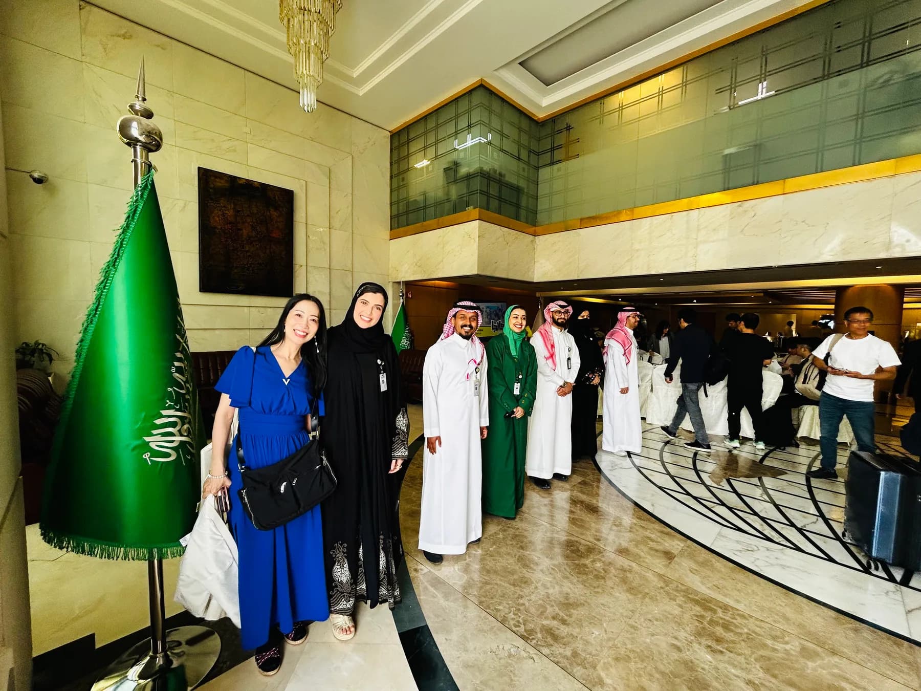 サウジアラビア国旗のある広間での集合写真。